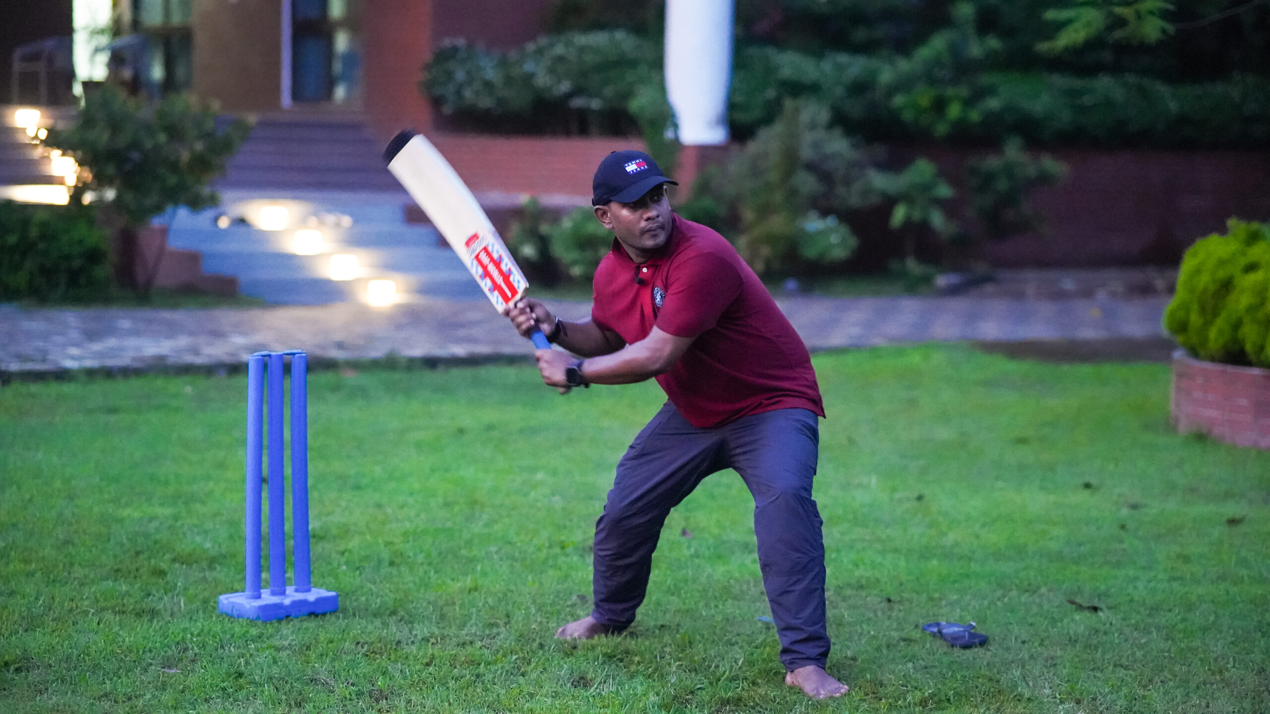 Guest playing cricket on the lawn at Neelpotro resort in the evening