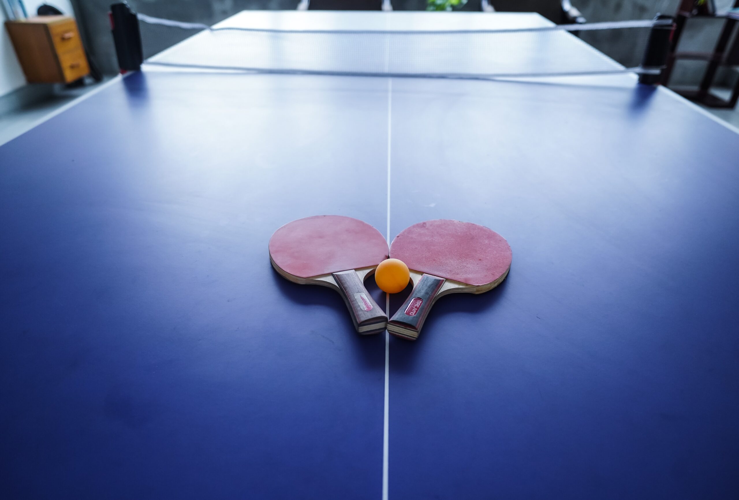 Table tennis paddles and ball at Neelpotro resort indoor games area